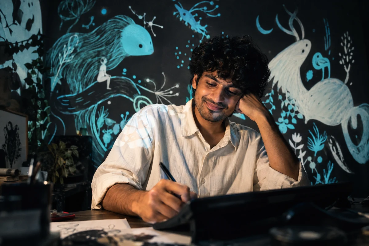 An artist sketching surrounded by imaginative cyan creatures